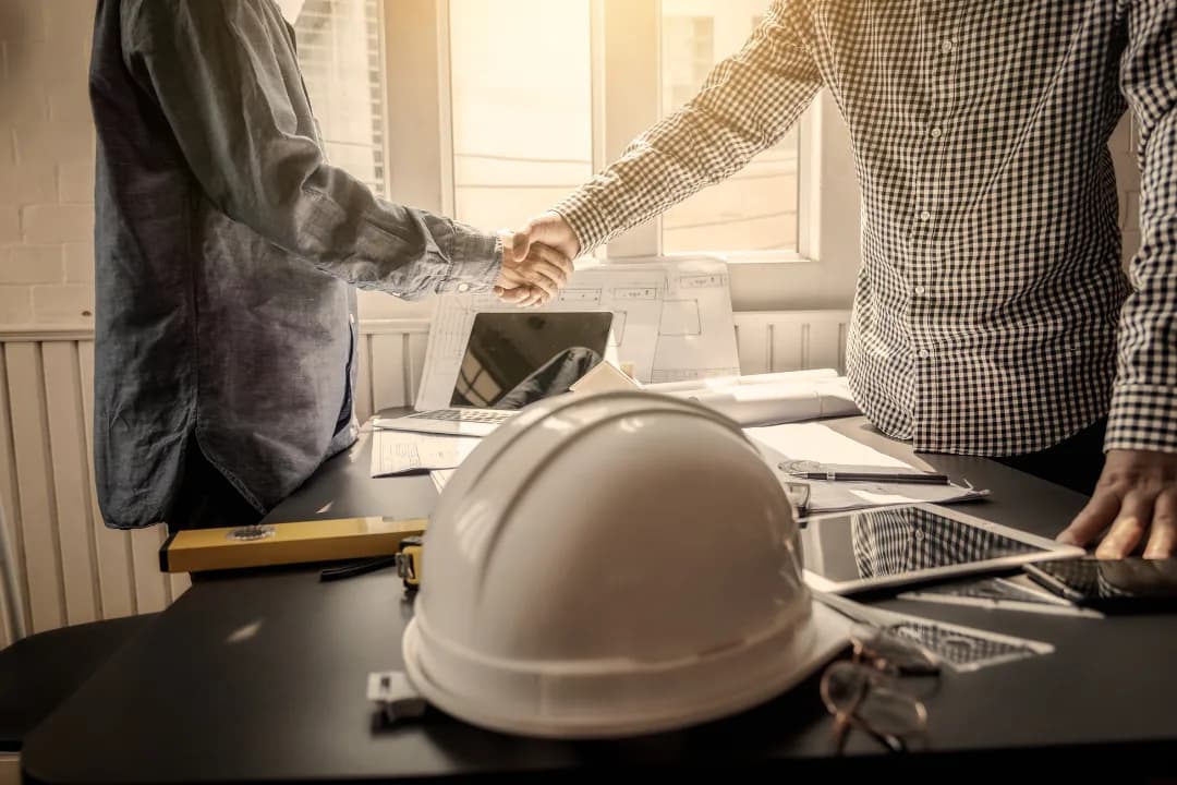 Office and field staff collaborate on planning for SCADA and DAS integration, with project documents and a hard hat on the table.