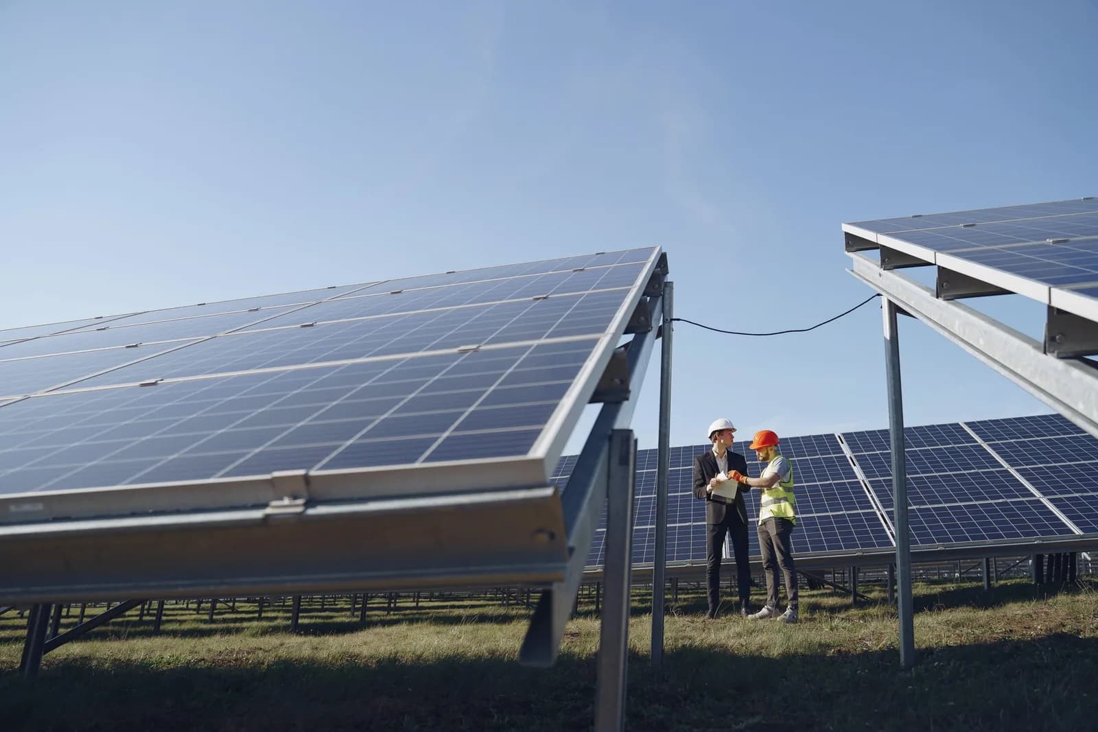 Field engineers review a utility-scale solar array, representing on-site coordination for solar SCADA and DAS integration work
